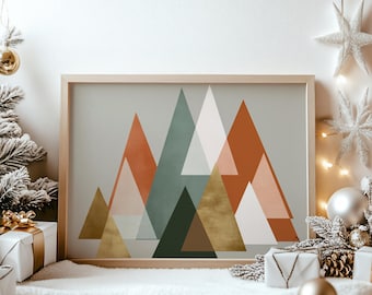 May include: A framed art print featuring a geometric mountain design. The artwork uses triangular shapes in shades of orange, green, white, and gold against a neutral background. The frame is made of light-colored wood, and the overall aesthetic is modern.