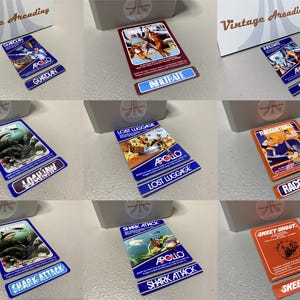 May include: A collection of nine rectangular video game cartridges and matching labels from Vintage Arcading, featuring titles like Guardian, Infiltrate, Lockjaw, Lost Luggage, Racquetball, Shark Attack, and Skeet Shoot with Apollo branding.