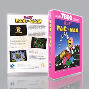 May include: A pink Atari 7800 video game cartridge case for Baby Pac-Man. The front cover features a yellow Pac-Man character with a pink bow, surrounded by colorful ghosts on a dark background. The back cover includes game text and screenshots.
