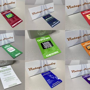 May include: A collection of vintage Atari game cartridges, each with unique game art and titles like "Barnstorming," "Beamrider," and "Boxing." The cartridges are displayed with a "Vintage Arcading" sign.