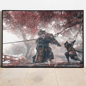 Può includere: Opera d'arte incorniciata raffigurante una drammatica scena di battaglia. Due figure in abiti tradizionali sono impegnate in combattimento con spade. Lo sfondo presenta un albero con foglie rosse, in contrasto con l'abbigliamento scuro.