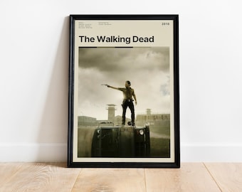 May include: Framed poster for "The Walking Dead" series. The poster features a man standing on a vehicle, holding a gun, with a cloudy sky background. The title "The Walking Dead" is displayed prominently.