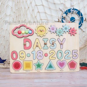 May include: Wooden puzzle board with the name "DAISY" and the date "09-18-2025" in colorful letters and numbers. Includes shapes like a circle, square, star, triangle, heart, and pentagon. Features a cloud, sun, and gears.