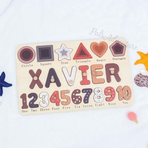 Peut inclure: Puzzle éducatif en bois avec le nom "XAVIER" en lettres multicolores, des formes et les chiffres de 1 à 10. Le puzzle comprend un cercle, un carré, une étoile, un triangle, un cœur et un pentagone. Les chiffres et les formes sont de couleurs variées.