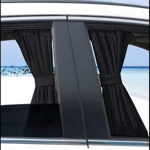 May include: A pair of black car window curtains installed on the side windows of a vehicle. The curtains are gathered in the center with a matching fabric tie-back, featuring a pleated design that covers the glass panels of the car doors.