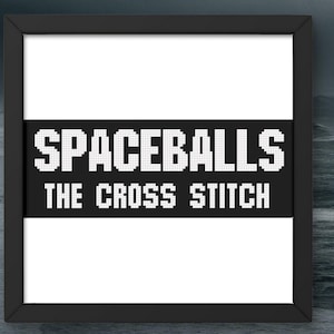 May include: A framed art print with the text "SPACEBALLS THE CROSS STITCH" in white pixelated letters on a black banner. The frame is black, and the background is a dark, stormy ocean scene.