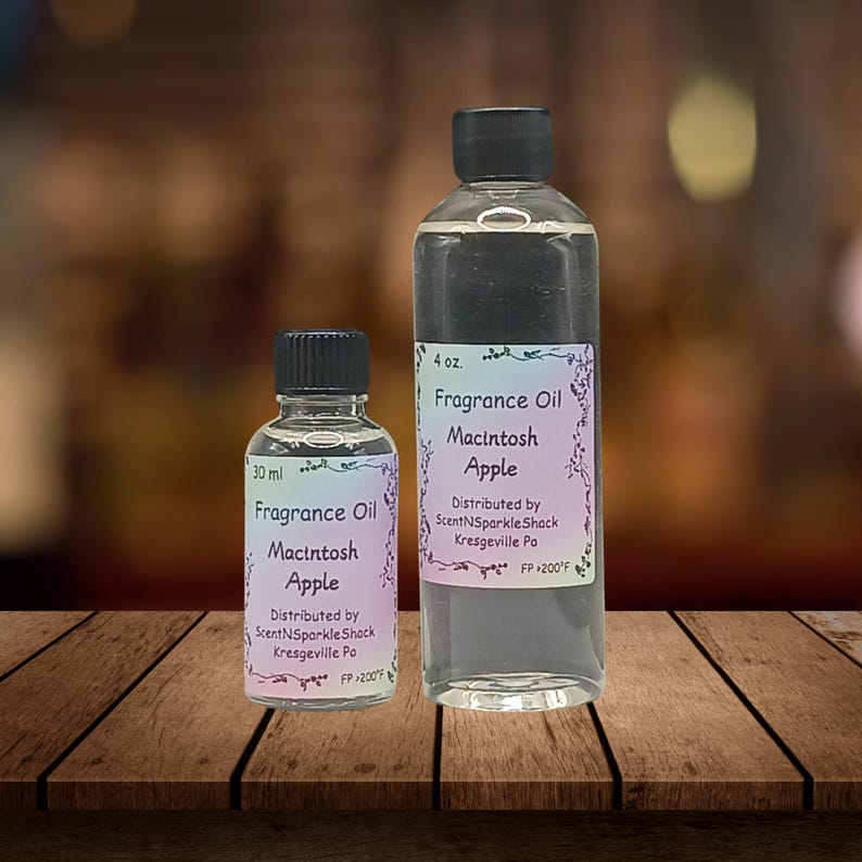Puede incluir: Dos botellas de vidrio transparente de aceite de fragancia "Macintosh Apple". Una botella es de 118 ml, la otra de 30 ml. Ambas tienen tapas negras y etiquetas con el texto "Fragrance Oil Macintosh Apple."