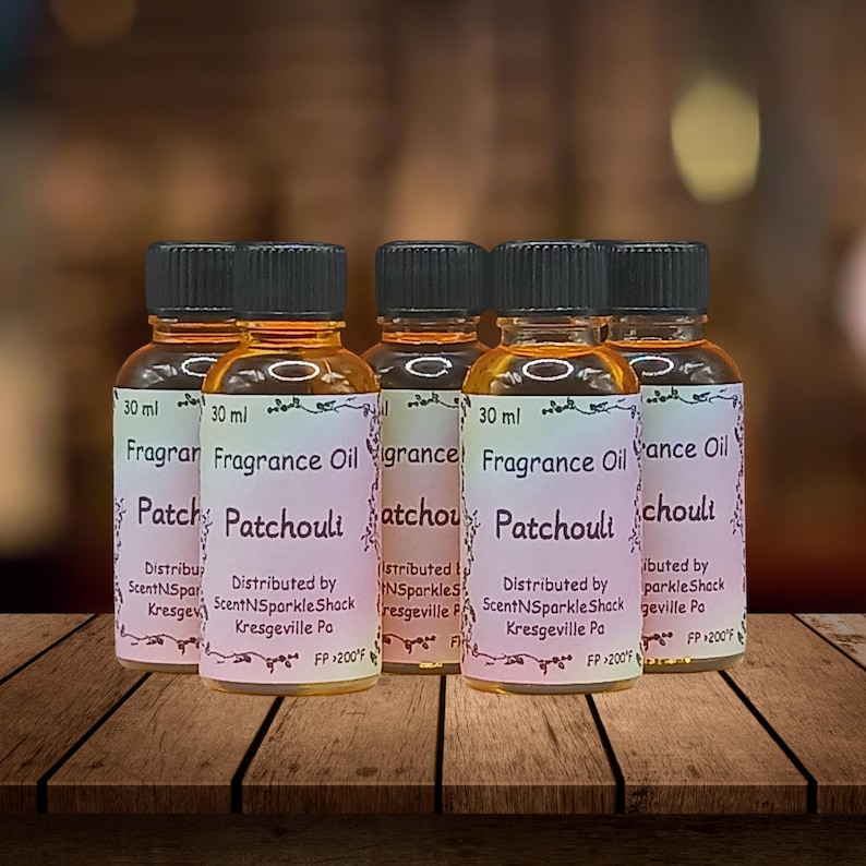 Puede incluir: Seis peque&ntilde;os frascos de vidrio de aceite de fragancia de pachul&iacute;, cada uno etiquetado "30 ml". Las etiquetas dicen "Fragrance Oil Patchouli" e incluyen informaci&oacute;n del distribuidor. Los frascos tienen tapas negras y aceite de color &aacute;mbar.