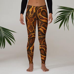 May include: Leggings with a detailed snake skin pattern in shades of brown, tan, and orange. The leggings feature a realistic design with scales and snake-like shapes. The garment is form-fitting and extends to the ankles.