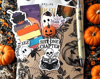 Könnte beinhalten: Ein Halloween-Geschenkset mit einem geisterförmigen Behälter. Das Set enthält Aufkleber, einen Stift und eine Kürbisdekoration. Der Hintergrund ist mit Kürbissen, Spinnweben und Spinnen dekoriert. Der Text "SPALIFE" ist sichtbar.