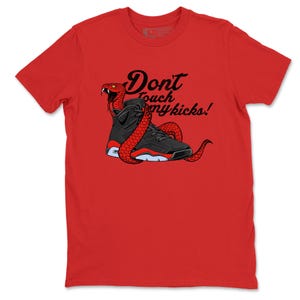 May include: Red t-shirt with a graphic of a black and red trainer with a red snake coiled around it. The text "Don't touch my kicks!" is printed above the trainer in black script.