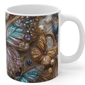 Puede incluir: Taza de cerámica blanca con un diseño detallado de mariposas. Las mariposas tienen patrones intrincados con detalles en azul, morado y dorado, adornadas con joyas y perlas. La taza tiene un asa blanca y un acabado brillante.