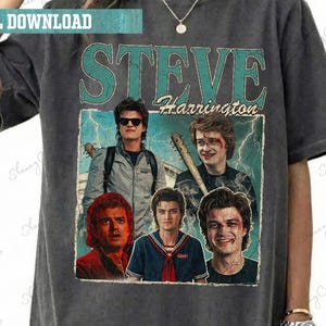 May include: Dark gray t-shirt featuring a vintage-style graphic of Steve Harrington from a popular TV show. The design includes the name "STEVE Harrington" and multiple images of the character. The shirt has a relaxed fit and short sleeves.