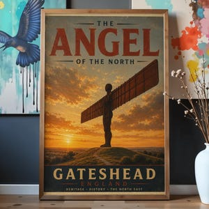 May include: A framed poster of the Angel of the North sculpture in Gateshead, England. The image shows the angel silhouetted against a sunset, with text reading "The Angel of the North" and "Gateshead England". The poster is in a wooden frame.