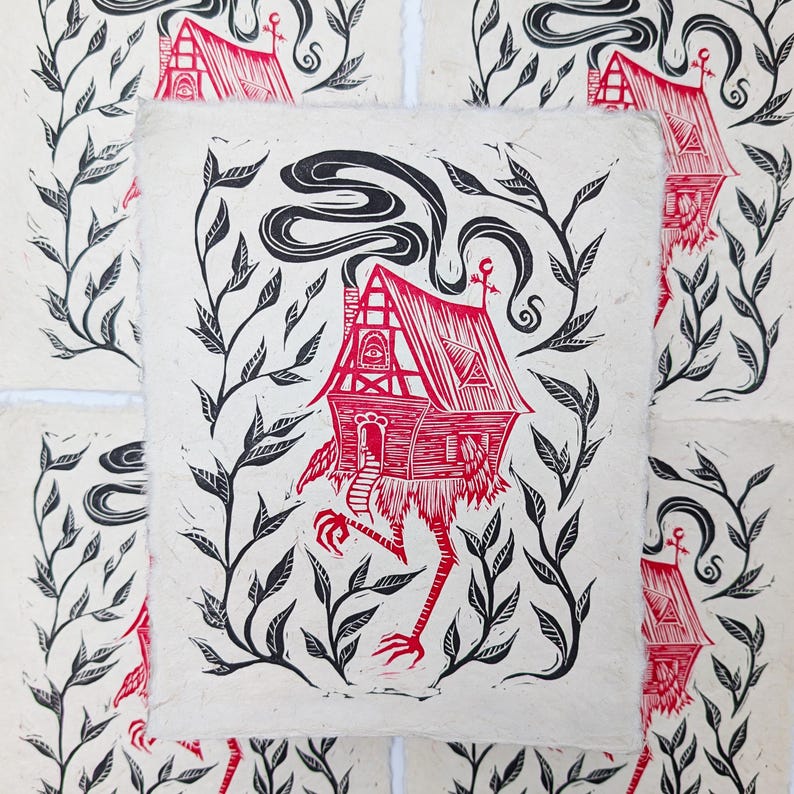 May include: Red and black linocut print of a house with legs, surrounded by black leafy vines. The house has a red roof, chimney smoke, and a door. The print is on textured, off-white paper.
