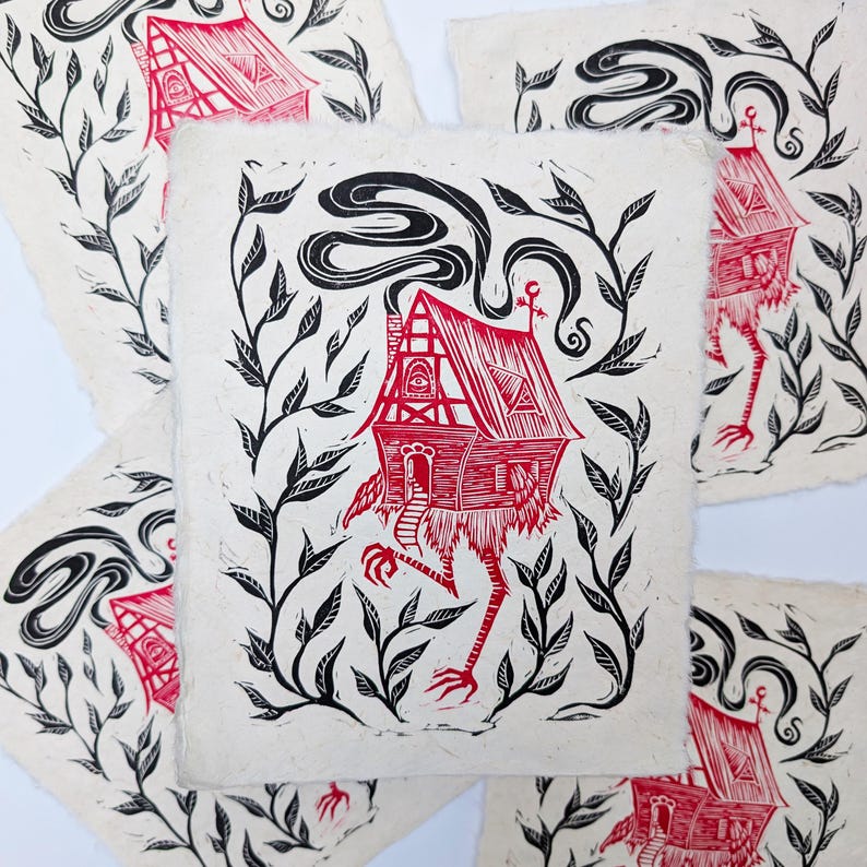 May include: A collection of red and black linocut prints featuring a whimsical house with long, bird-like legs, a smoking chimney, and surrounded by leafy vines. The house has a detailed facade and is printed on textured paper.
