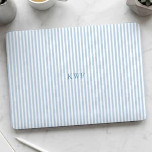 May include: A rectangular laptop skin featuring a vertical pinstripe pattern in light blue and white. The center of the skin displays the monogram letters KWF in a serif font, matching the light blue color of the vertical stripes.