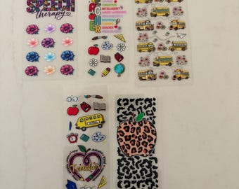 May include: Five vertical sticker sheets featuring various designs. One sheet has floral patterns and the text Speech Therapy. Another has school-themed icons and the word TEACHER. A third shows yellow school buses. A fourth has school icons and a heart shape with the word Teacher. The fifth has two large leopard print apples.