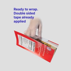 May include: A red and white chocolate bar box with the text "Ready to wrap. Double sided tape already applied." The box has a nutrition facts label and the words "CREATIVE LOVE CHOCOLATE BAR".