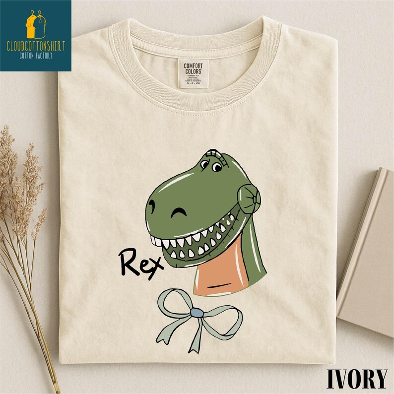 a white t-shirt with a cartoon dinosaur graphic and the name "Rex" printed on it.