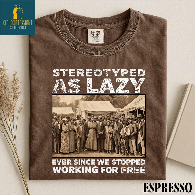 May include: Espresso-colored t-shirt with the text "STEREOTYPED AS LAZY" above a sepia-toned photo of a group of people. Below the photo, the text reads "EVER SINCE WE STOPPED WORKING FOR FREE."