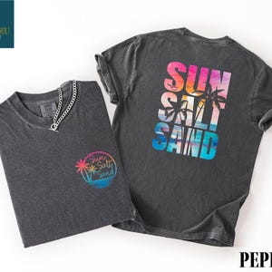 a gray t-shirt with a colorful graphic design on the back, along with a smaller gray t-shirt on the left side.