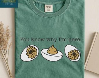 May include: Light green t-shirt with the text "You know why I'm here." and illustrations of deviled eggs. The shirt has a crew neck and a Comfort Colors tag. The words "LIGHT GREEN" are at the bottom.