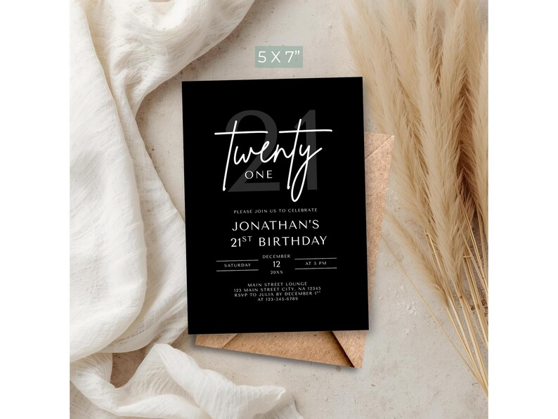 May include: A black 5x7 inch invitation card with the text "Twenty One" in white script. The card is for Jonathan's 21st birthday, with the date and time listed. The card is on a neutral background with dried plants.