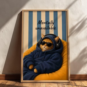 Könnte beinhalten: Ein gerahmter vertikaler Wandkunstdruck mit einer orangefarbenen Katze, die einen dunkelblauen Kapuzenpullover, eine schwarze Sonnenbrille und einen schwarzen Kopfhörer trägt. Die Katze sitzt in einem gelben Sitzsack vor einem blau-cremefarbenen Streifenhintergrund mit dem Text Mentally unavailable.