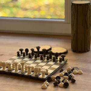 May include: A white ceramic mug with a black handle and the text "But First, Coffee" in a black, bold font. The mug is sitting on a wooden surface. The mug is approximately 4 inches tall.