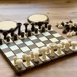 May include: A unique chess set featuring mushroom-shaped pieces in shades of brown and cream. The board is black and white, with two wooden coasters in the background. The chess pieces are intricately designed, adding a whimsical touch to the classic game.