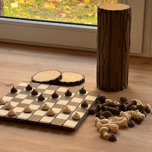 May include: A white ceramic mug with a black handle and the text "But First, Coffee" in a bold, black font. The mug is set against a blurred background, suggesting a cozy setting.