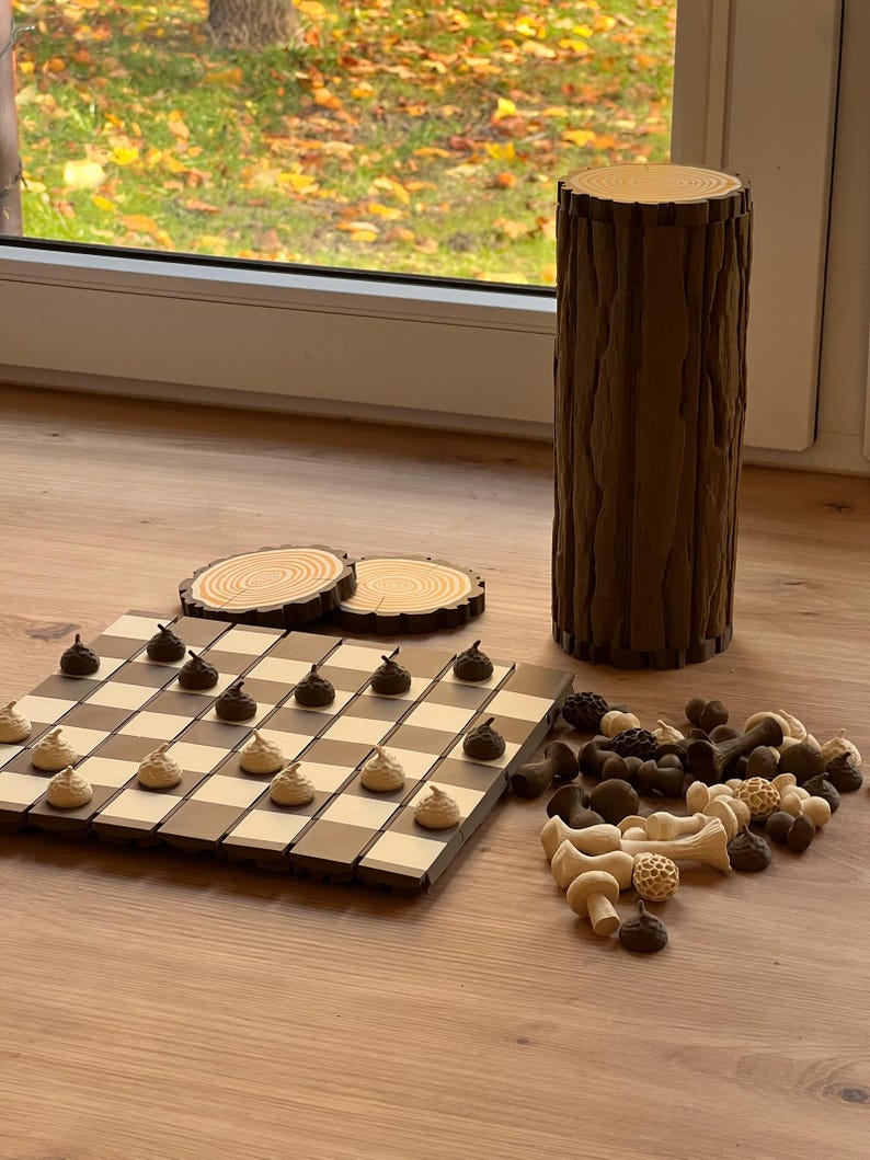May include: A white ceramic mug with a black handle and the text "But First, Coffee" in a bold, black font. The mug is set against a blurred background, suggesting a cozy setting.