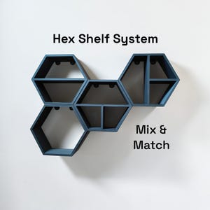 May include: A blue hexagon shelf system with the text "Hex Shelf System" and "Mix & Match". The shelves are mounted on a white wall. The shelves are empty.