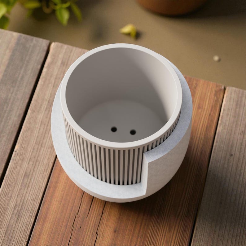 May include: A light gray cylindrical planter featuring a vertical ribbed texture on the exterior and a smooth interior basin. The base of the planter includes two small drainage holes visible at the bottom of the interior compartment.