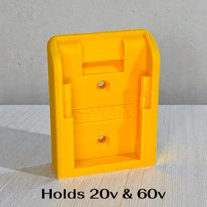 May include: Bright yellow plastic power tool holder with the brand name "DEWALT" embossed on the front. The holder has two circular holes and the text "Holds 20v & 60v" at the bottom.