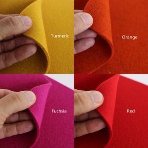 K&ouml;nnte beinhalten: Vier Filzquadrate in verschiedenen Farben: Kurkuma, Orange, Fuchsia und Rot. Jedes Quadrat wird von einer Hand gehalten, wodurch die Textur des Filzes sichtbar wird.