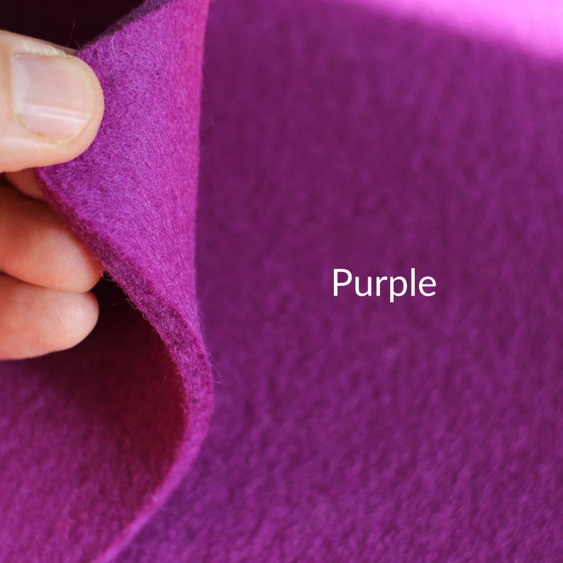 May include: A close-up of a purple felt fabric. The fabric is soft and textured, and the color is a rich, deep purple.