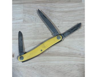 Cuchillo Kabar USA 1097 Birdseye Stockman con mangos de material compuesto amarillo liso.