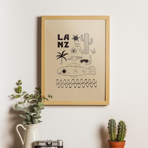 Puede incluir: Un cuadro enmarcado con fondo beige e ilustraciones negras. El cuadro presenta las letras "LA NZ", un cactus, una palmera, un pez y otros dibujos con temática desértica y oceánica. El marco es de madera clara.