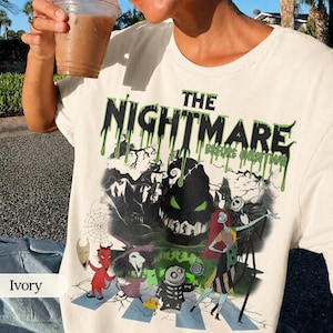 K&ouml;nnte beinhalten: Elfenbeinfarbenes T-Shirt mit einem Grafikmotiv aus "The Nightmare Before Christmas". Das Design zeigt den Filmtitel in gr&uuml;nen, tropfenden Buchstaben sowie Charaktere wie Jack Skellington und Sally. Das Shirt hat einen Rundhalsausschnitt.
