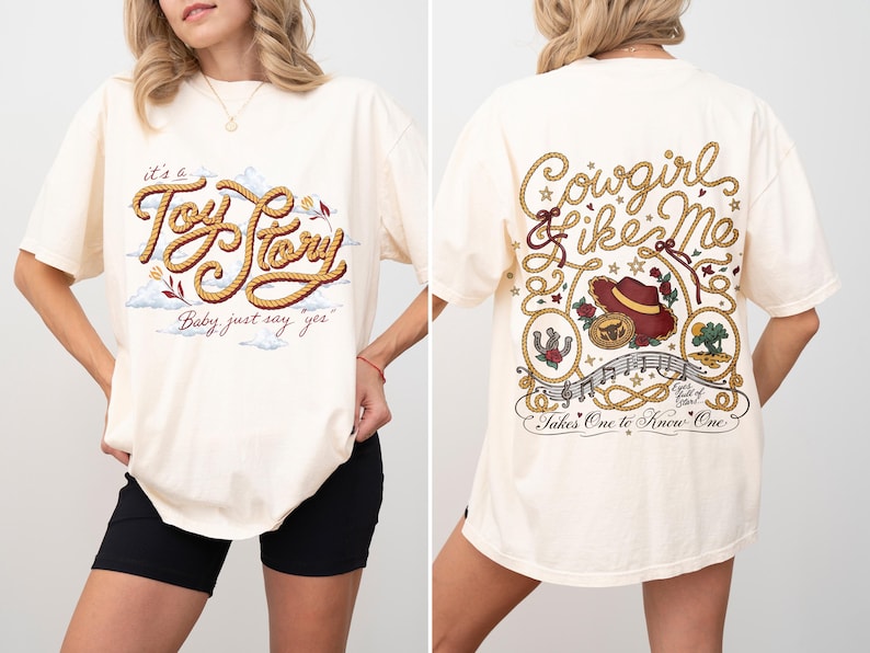 May include: An off-white short-sleeve t-shirt featuring a front graphic with rope-style text reading "it's a Toy Story" and "Baby just say yes". The back graphic displays "Cowgirl Like Me" with a cowboy hat, horseshoe, and musical notes.