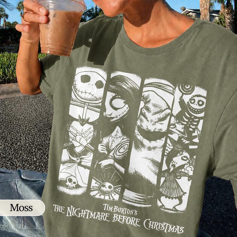 K&ouml;nnte beinhalten: Ein moosgr&uuml;nes T-Shirt mit einem wei&szlig;en Grafikdruck von Charakteren aus Tim Burton's The Nightmare Before Christmas. Das Design besteht aus vier vertikalen Feldern, die Jack Skellington, Sally, Oogie Boogie und weitere Figuren zeigen.