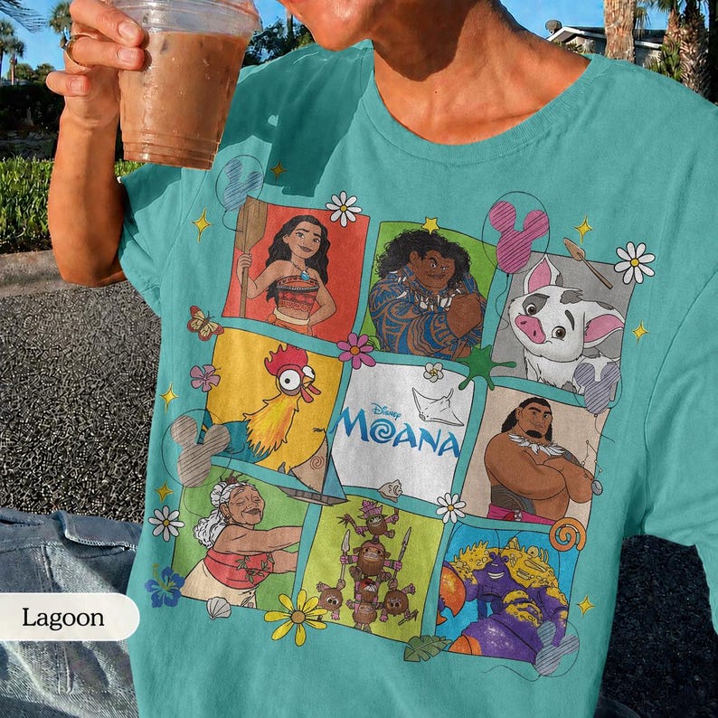 Op de afbeelding: Tealkleurig T-shirt met een kleurrijke afbeelding van personages uit de Disney-film Moana. Het ontwerp bevat afbeeldingen van Moana, Maui, Pua, Hei Hei en anderen, met het logo van de film in het midden. Het shirt is een comfortabele, casual stijl.