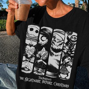 K&ouml;nnte beinhalten: Ein schwarzes T-Shirt mit einem wei&szlig;en Grafikdruck von Charakteren aus Tim Burton's The Nightmare Before Christmas, darunter Jack Skellington, Sally und Oogie Boogie, angeordnet in vertikalen Feldern mit dem Filmtitel darunter.