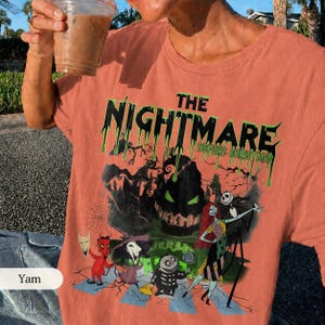 K&ouml;nnte beinhalten: Korallenfarbenes T-Shirt mit einem Grafikdesign aus "The Nightmare Before Christmas". Das Design zeigt den Filmtitel in tropfenden gr&uuml;nen Buchstaben sowie Charaktere wie Jack Skellington und Sally. Das Shirt hat einen klassischen Rundhalsausschnitt.
