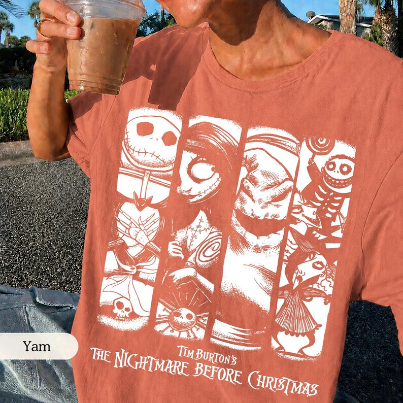 K&ouml;nnte beinhalten: Ein terrakottafarbenes T-Shirt mit einem wei&szlig;en Grafikdruck von Charakteren aus Tim Burton's The Nightmare Before Christmas. Das Design besteht aus vier vertikalen Feldern, die Jack Skellington, Sally, Oogie Boogie und weitere Figuren zeigen.