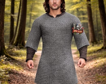 May include: A silver chainmail tunic with short sleeves and a brown undershirt. The tunic has a V-neck and a patch on the upper arm that reads "REN FAIRE US". The person is wearing black pants and boots.