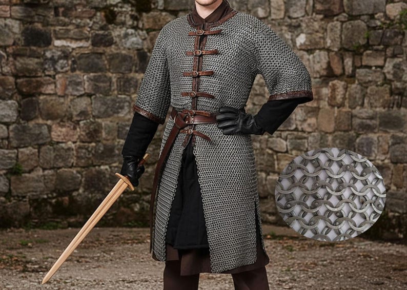May include: A medieval-style chainmail shirt with leather accents and a brown leather belt. The shirt has short sleeves and is fastened with leather straps. A wooden sword is held in the left hand. The background is a stone wall.