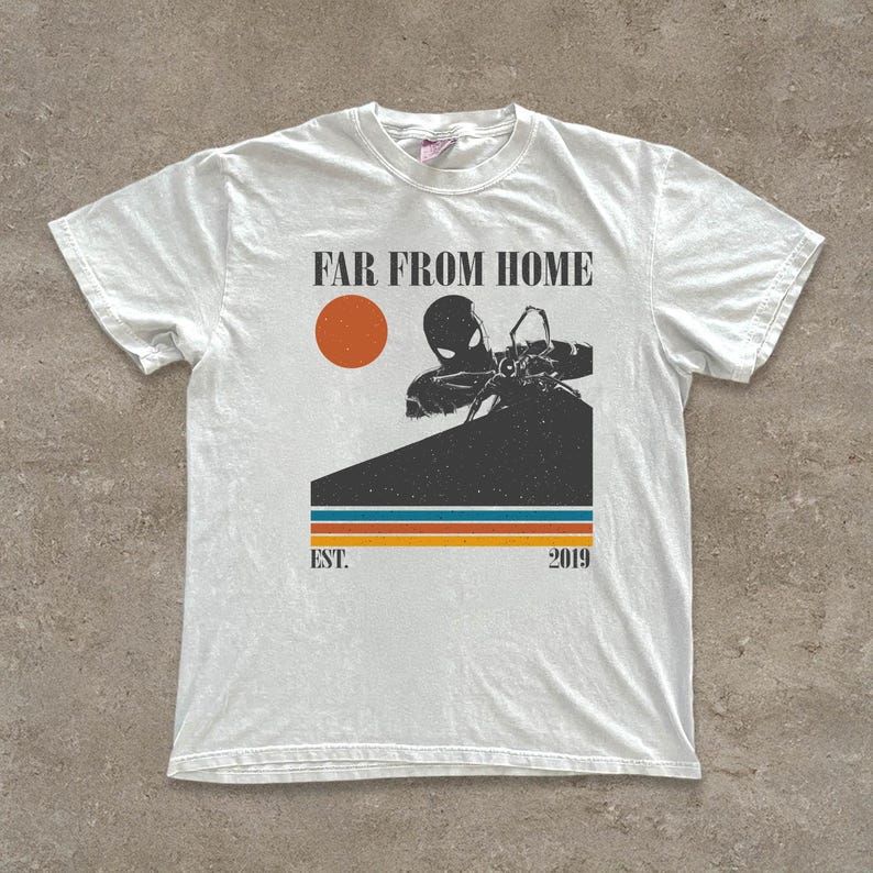 May include: White t-shirt with a graphic design. The design includes the text "FAR FROM HOME", an orange sun, and a character silhouette. Below the graphic are the words "EST. 2019" and three horizontal stripes.